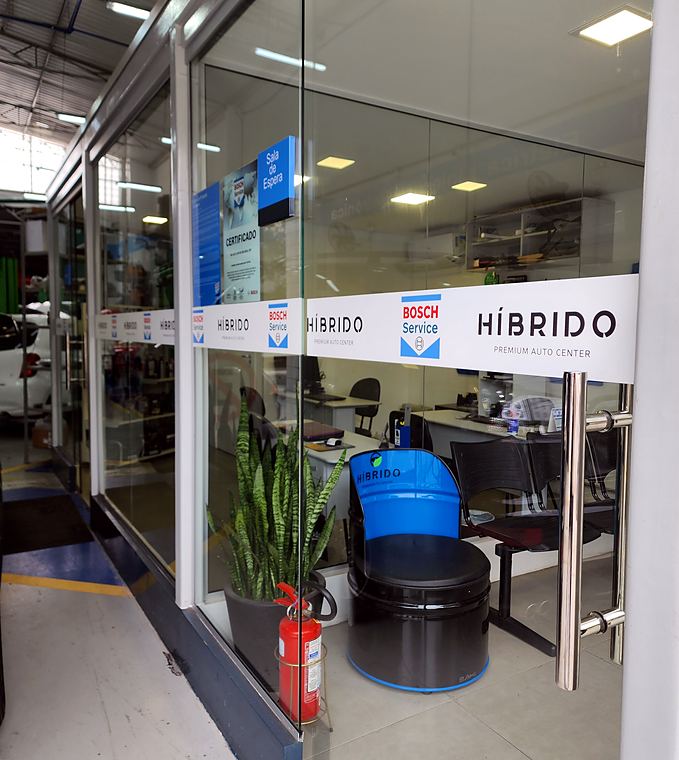Sala de espera envidraçada da Híbrido com a marca Bosch Service na porta